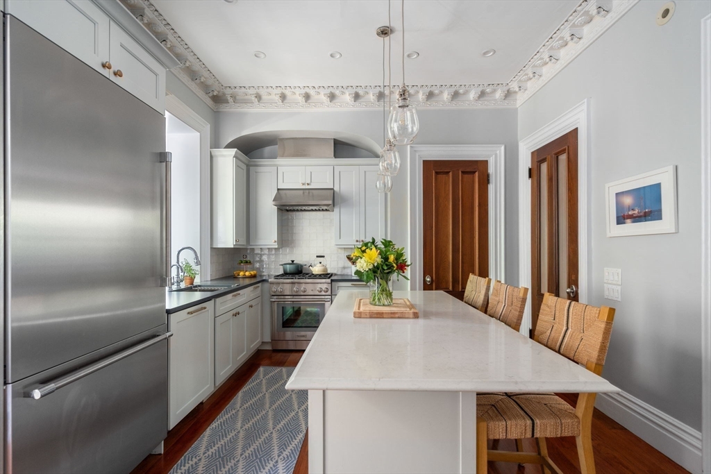32 Rutland Square, Unit 1 Boston, MA 02118 - Photo 4 of 24 a kitchen with a table chairs refrigerator and cabinets