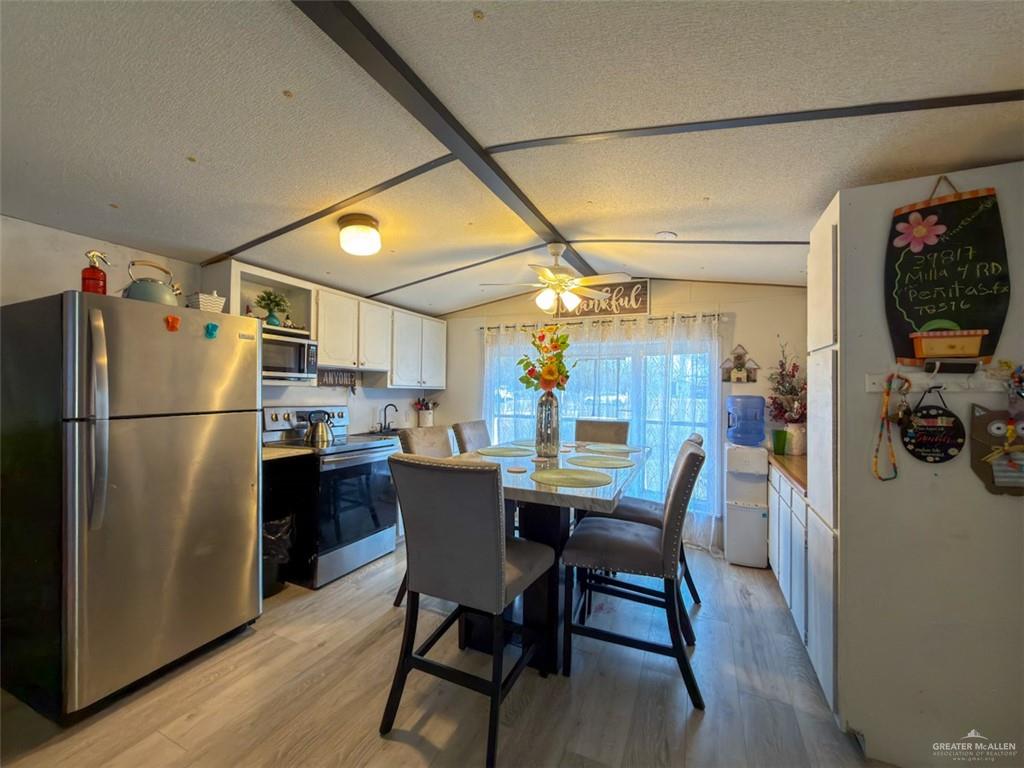 39817 Mile 4 Road Penitas, TX 78576 - Photo 6 of 19 a kitchen with stainless steel appliances a dining table chairs refrigerator and cabinets
