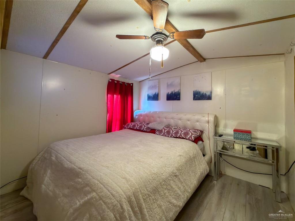 39817 Mile 4 Road Penitas, TX 78576 - Photo 7 of 19 a spacious bedroom with a bed and a chandelier