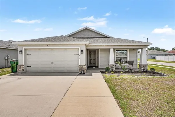 a front view of house with yard outdoor seating and garage