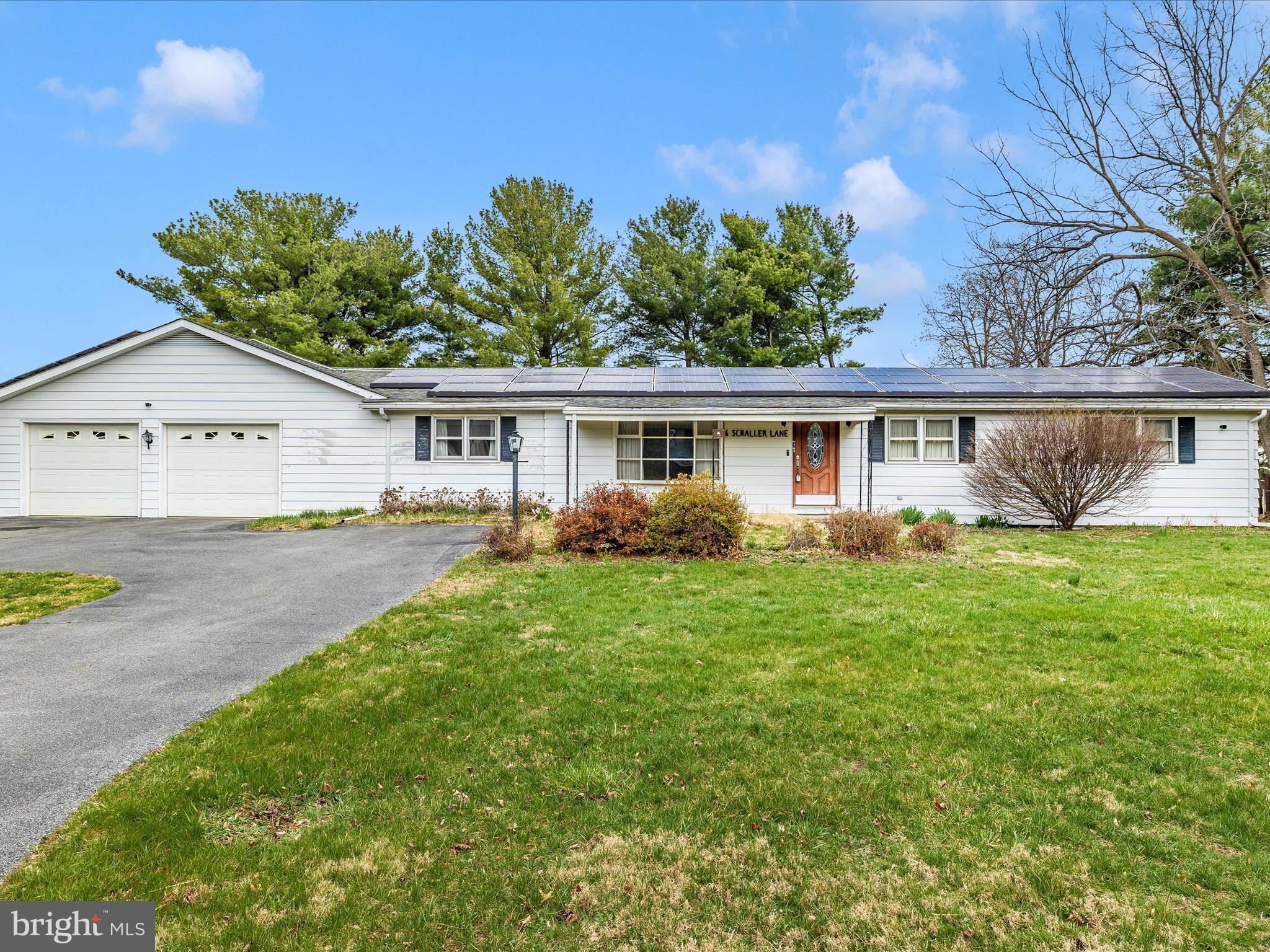 a view of a house with a yard and potted plants