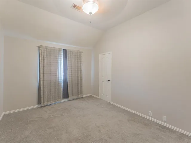 an empty room with a chandelier fan