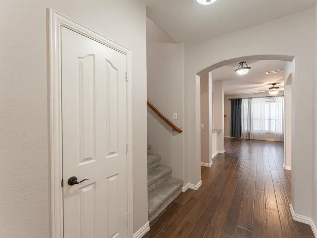 a view of a hallway with wooden floor and closet area