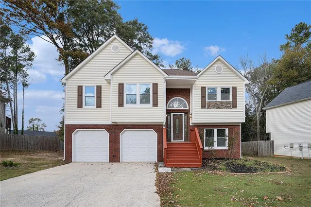 a front view of a house with a yard and garage