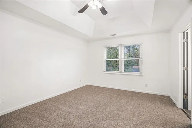 an empty room with a window and a ceiling fan