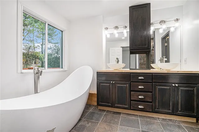 a spacious bathroom with a bathtub sink and double vanity