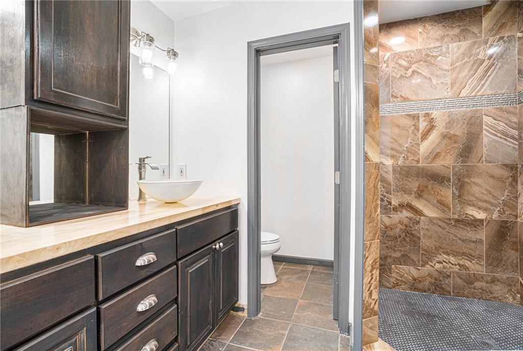 4208 Mistymorn Point Powder Springs, GA 30127 - Photo 14 of 28 a bathroom with a granite countertop sink a mirror and a shower