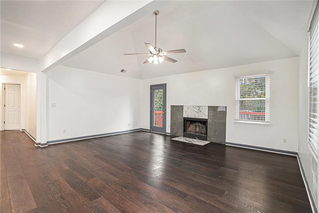 4208 Mistymorn Point Powder Springs, GA 30127 - Photo 6 of 28 an empty room with windows fireplace and wooden floor