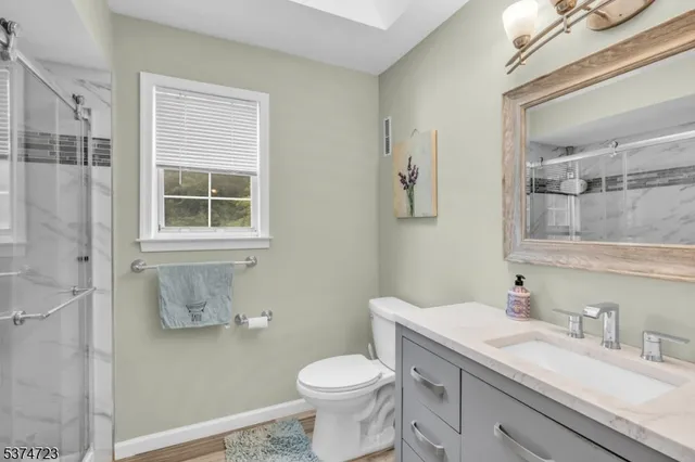 a bathroom with a granite countertop toilet sink and mirror