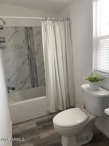 a white toilet sitting next to a bath tub