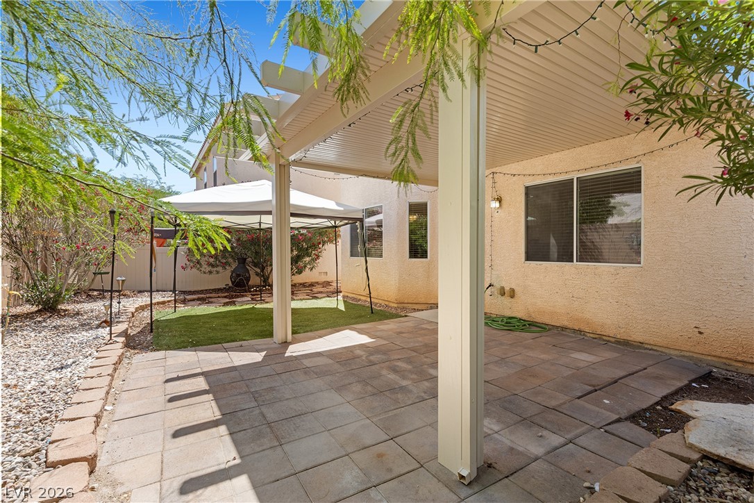 8934 Deep Ridge Court Las Vegas, NV 89178 - Photo 29 of 47 A spacious private yard features a covered patio with string lights, ideal for outdoor gatherings.