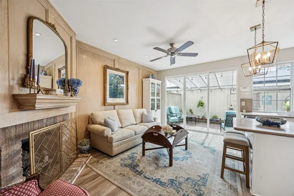a living room with furniture a chandelier and a fireplace