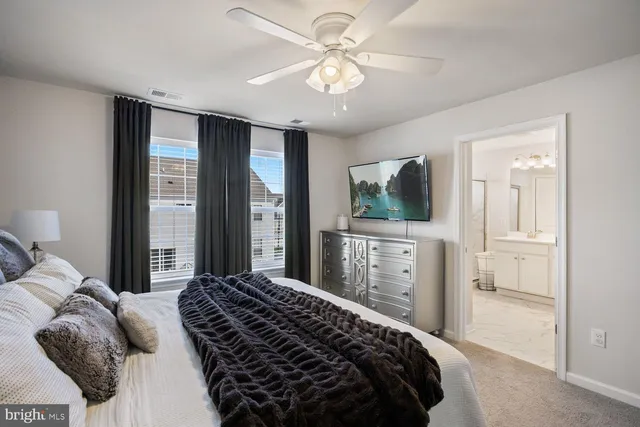 a bedroom with a large bed and a chandelier