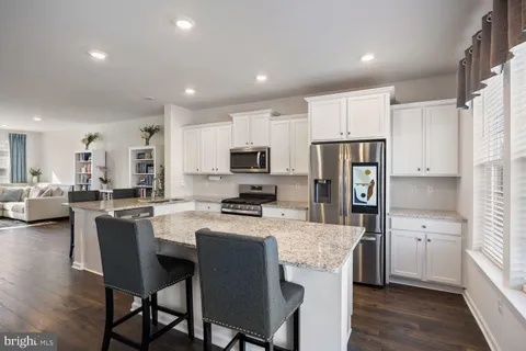 a room with kitchen island a sink dishwasher a dining table and chairs with wooden floor