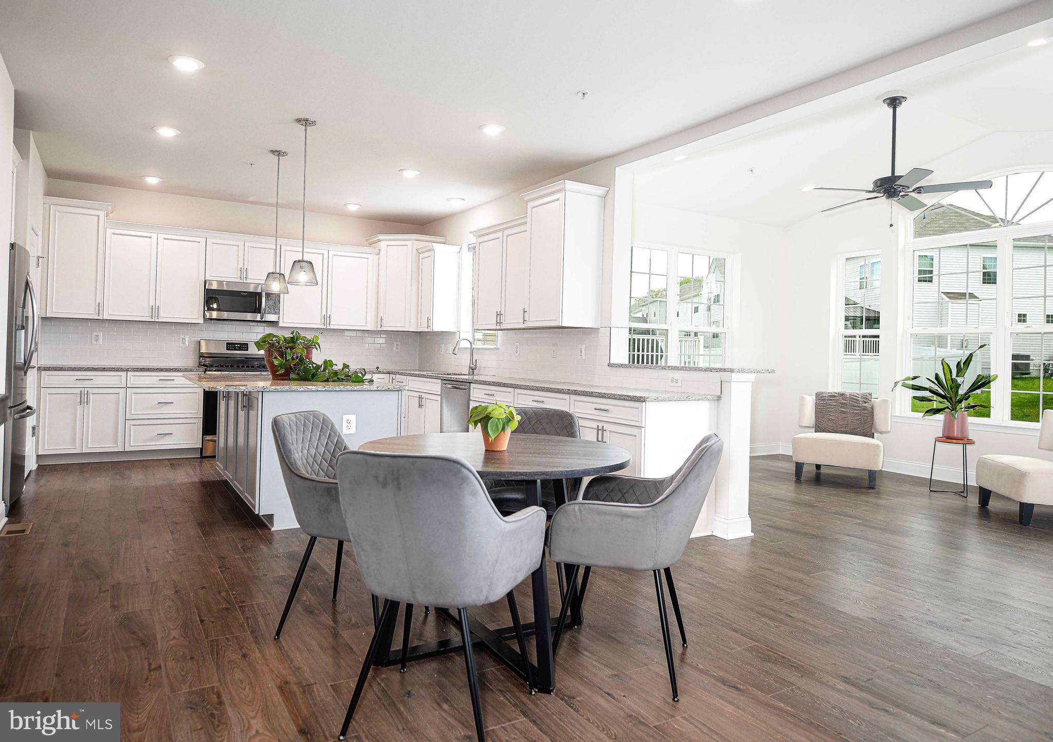 1218 Up And Over Lane Aberdeen, MD 21001 - Photo 15 of 40 a kitchen with kitchen island a dining table chairs and white cabinets