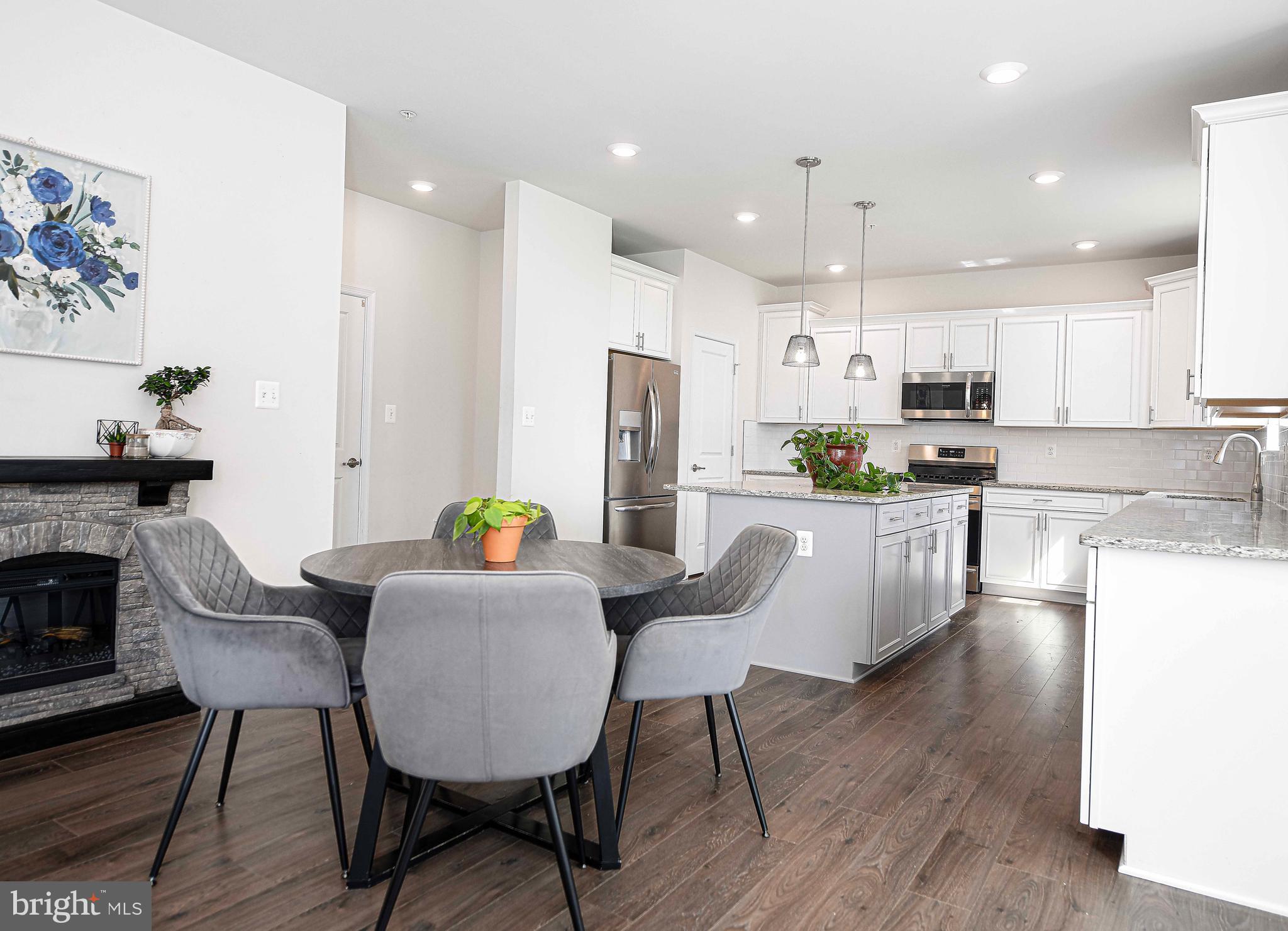 1218 Up And Over Lane Aberdeen, MD 21001 - Photo 16 of 40 a kitchen with refrigerator a stove a dining table and chairs with wooden floor
