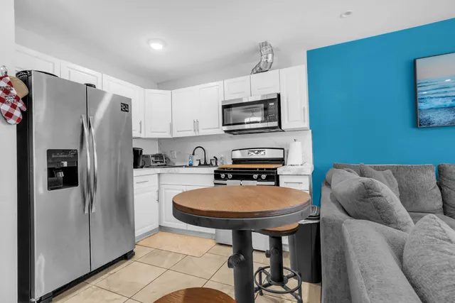 a kitchen with stainless steel appliances a refrigerator a sink a stove a microwave a counter top space and cabinets