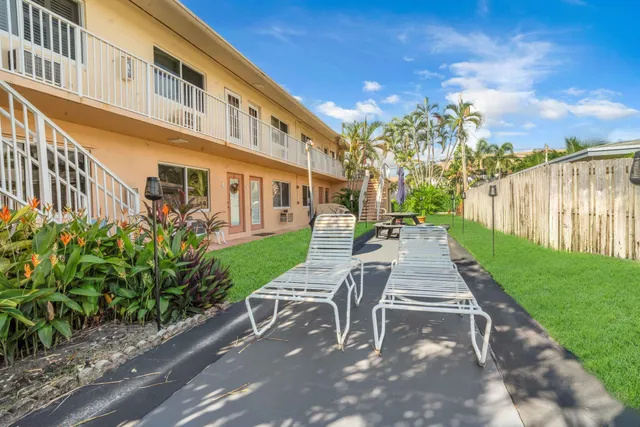 a view of a house with backyard and sitting area