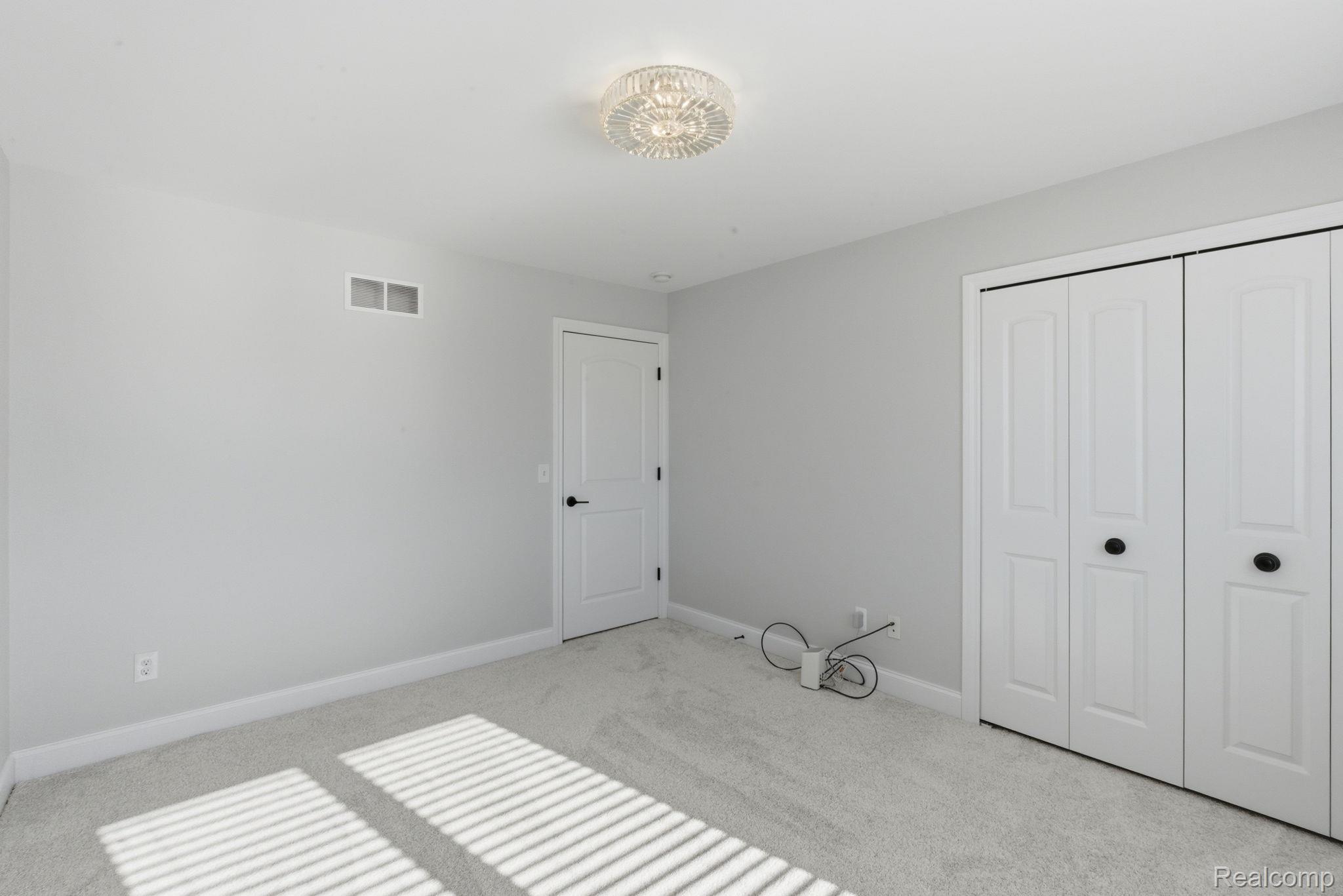 8844 Ridge Drive Washington, MI 48095 - Photo 25 of 51 Unfurnished bedroom featuring light carpet and a closet
