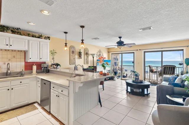 a large white kitchen with lots of counter space and painting on the wall