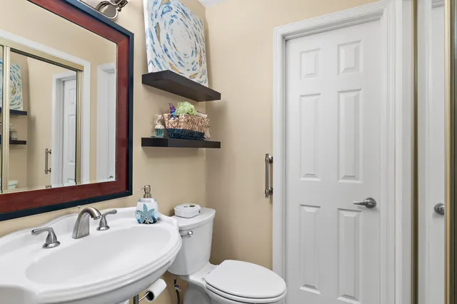 a bathroom with a toilet sink and mirror