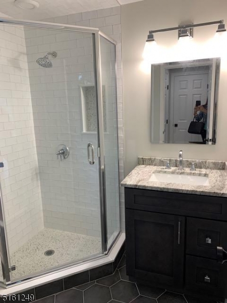 518 Trinity Place, Unit 2 Westfield, NJ 07090 - Photo 10 of 11 a bathroom with a granite countertop sink shower and a mirror