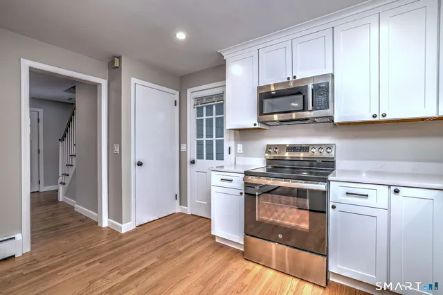 a kitchen with stainless steel appliances granite countertop a stove and a microwave
