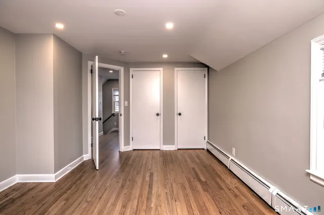 a view of hallway with a large window and wooden floor