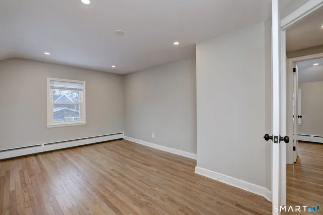an empty room with wooden floor and a window