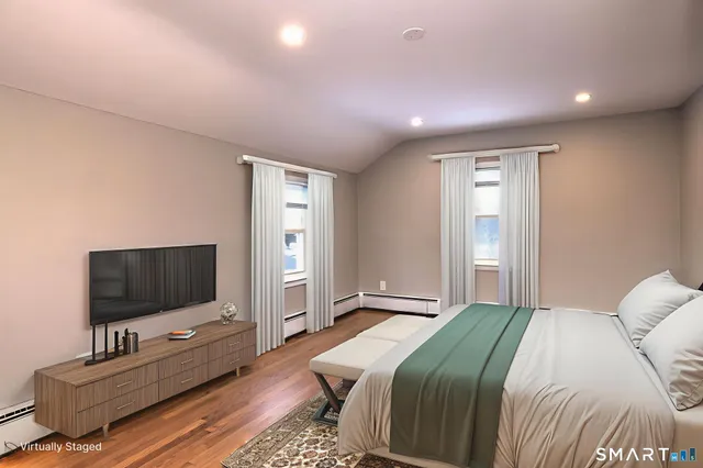 a bedroom with a bed and a flat screen tv