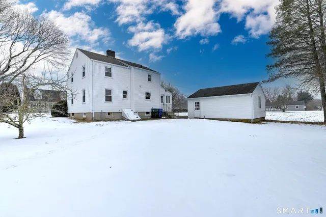 a view of garage with a white house