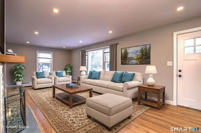 a living room with fireplace furniture and a rug