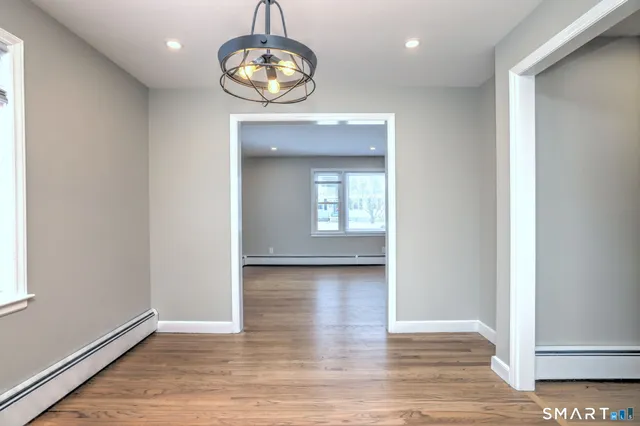 an empty room with wooden floor and mirror