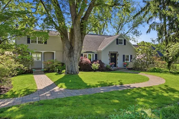 a front view of a house with a yard and trees