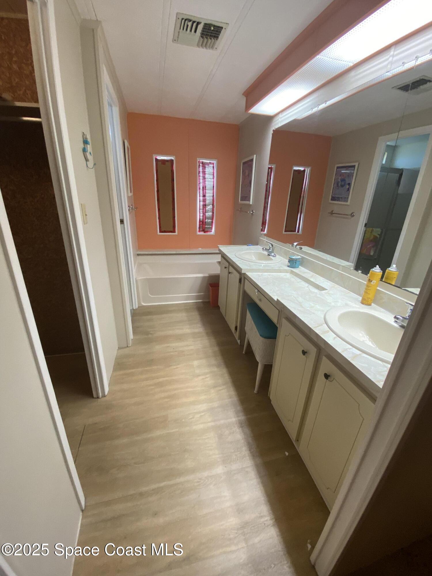 1906 Mango Street Northeast Palm Bay, FL 32905 - Photo 16 of 42 a bathroom with a tub sink and mirror