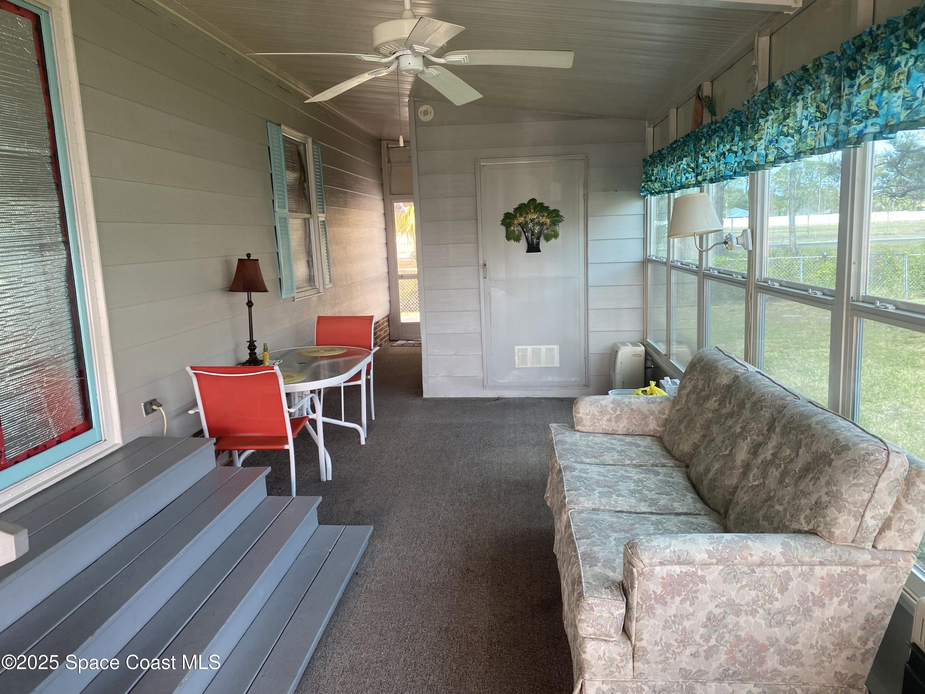 1906 Mango Street Northeast Palm Bay, FL 32905 - Photo 5 of 42 a living room with furniture and a floor to ceiling window