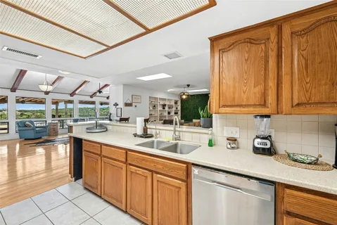 a kitchen with stainless steel appliances granite countertop a sink a stove cabinets and wooden floor