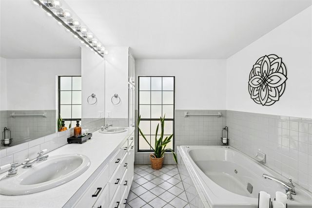 a bathroom with a tub sink and mirror