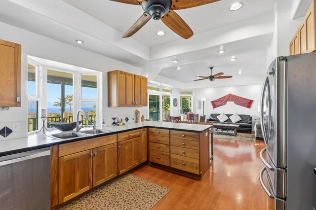 a kitchen with stainless steel appliances granite countertop a sink dishwasher and a stove with wooden floor