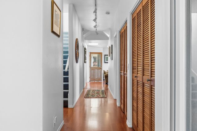 a view of a hallway with wooden floor and staircase