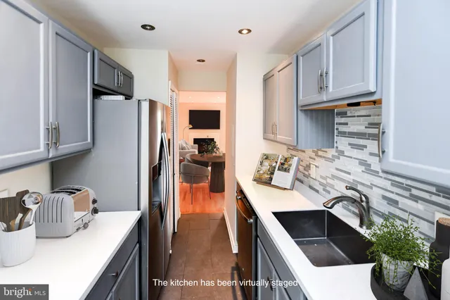 a kitchen with a refrigerator sink and cabinets
