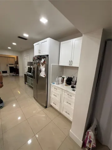 a kitchen with a refrigerator a sink and cabinets