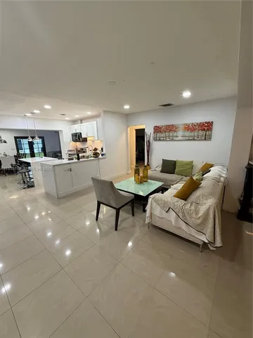a living room with furniture and kitchen view
