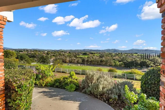 a large white kitchen with a stove a sink dishwasher and a fireplace with wooden floor