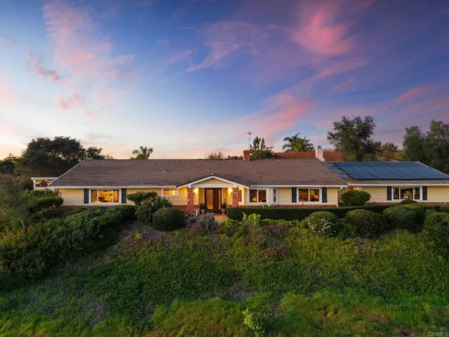an aerial view of residential houses with outdoor space and ocean view