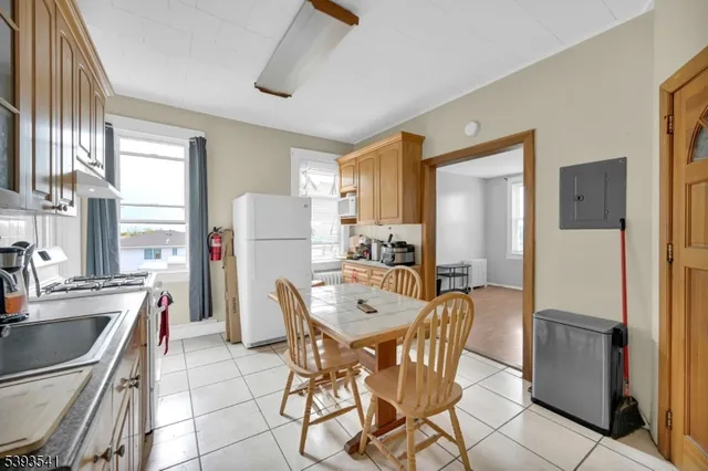 a living room with furniture and a refrigerator