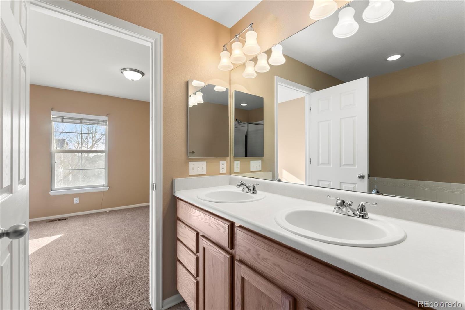 2020 Squawbush Ridge Grove Colorado Springs, CO 80910 - Photo 10 of 29 a bathroom with a sink double vanity and a mirror