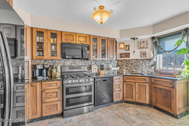 a kitchen with stainless steel appliances granite countertop a stove and cabinets