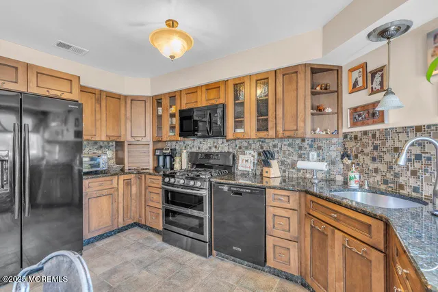 a kitchen with stainless steel appliances granite countertop a stove refrigerator and cabinets