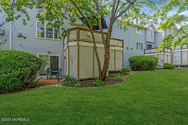 a view of a backyard with potted plants and large trees